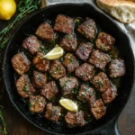 Garlic butter steak bites in cast iron skillet with garlic and herbs – sizzling and juicy, ready to serve.